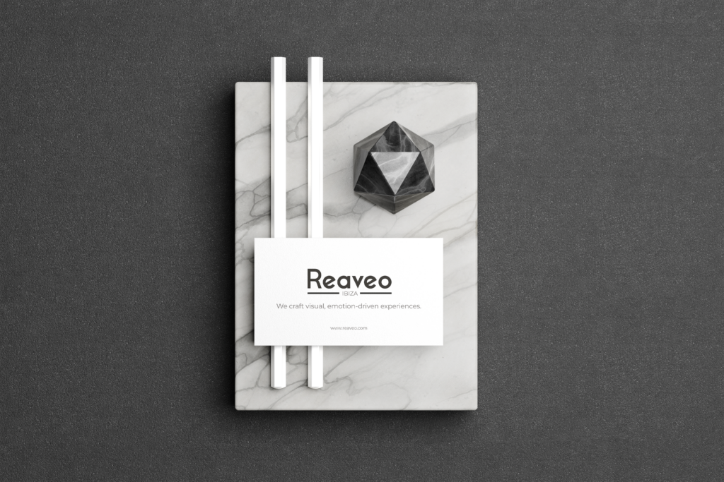 A visual display with office material and a card with Reaveo logo