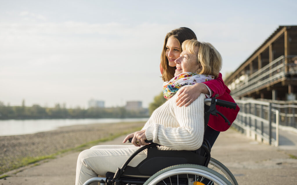 Granddaughter hugging her grandmother sitting in wheelchair